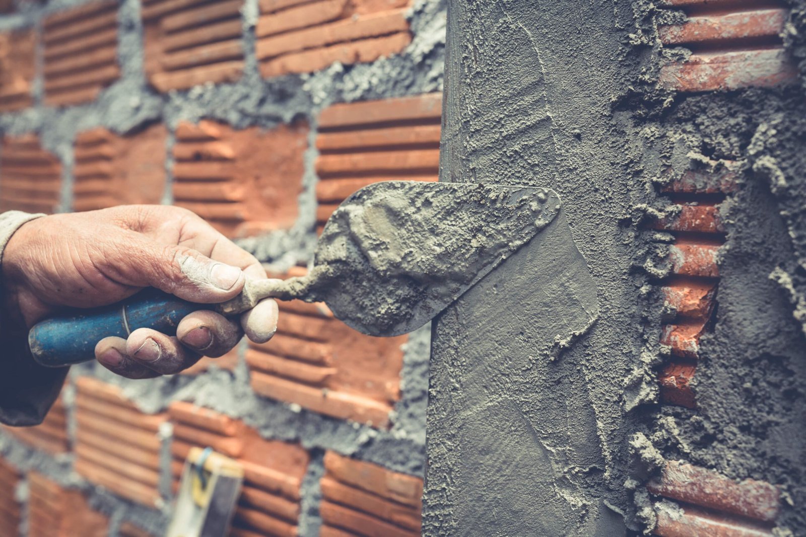 bricklaying-construction-worker-building-brick-wall-min