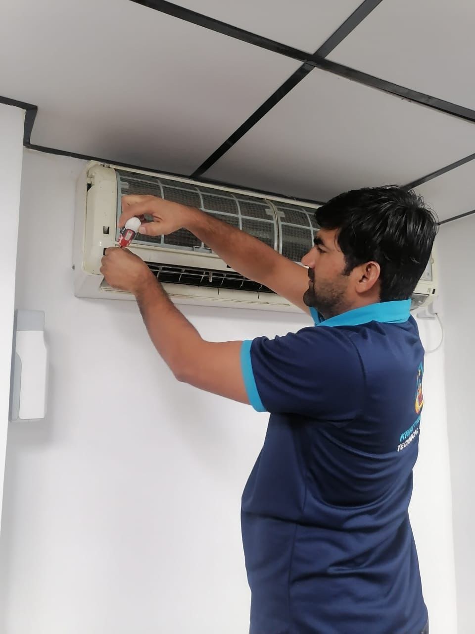 Rapid Home technician servicing a wall-mounted split AC unit